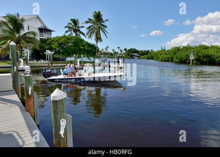 Bateau à moteur laissant dock sur la verseuse Creek, Bokeelia, Pine Island, Floride, USA Banque D'Images