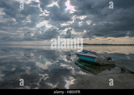 Bateau de Moteur touristique sur la plage de Gili Air à Lombok avec réflexion nuages Banque D'Images