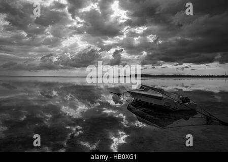 Bateau de Moteur touristique sur la plage de Gili Air à Lombok avec réflexion nuages Banque D'Images