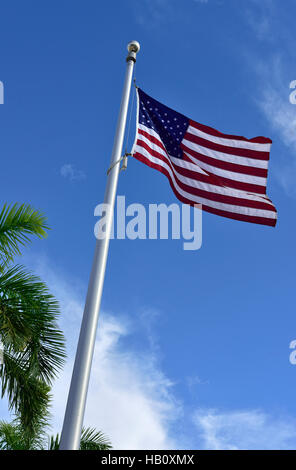 American flag flying sur mât contre le ciel bleu Banque D'Images