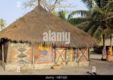 Les Diola.s de chaume maison townrural avec palm-montées des murs décorés de motifs africains traditionnels dans le village de l'île de Karabane Banque D'Images
