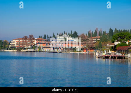 Vue ensoleillée du centre-ville de Sirmione, avec une baignoire spa et des bâtiments et le lac de Garde en premier plan. Banque D'Images