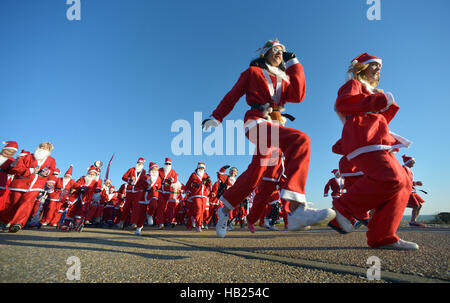 Eastbourne, East Sussex. 4e décembre 2016. La charité Santa courir le long de la mer pour Myaware la charité. Banque D'Images