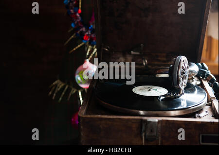 La lecture d'un gramophone record. avec du vinyle sur fond de décorations, cap, d'arbres et lumières lumineuses Banque D'Images