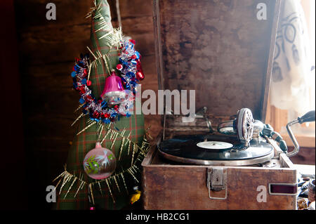 La lecture d'un gramophone record. avec du vinyle sur fond de décorations, cap, d'arbres et lumières lumineuses Banque D'Images