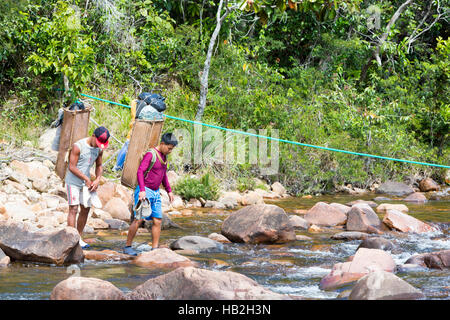 MT RORAIMA, VENEZUELA, 1 avril : Deux guides autochtones indiennes locales avec la traversée du fleuve vénézuélien traditionnels sacs à dos pour le transport de marchandises sur la voie t Banque D'Images