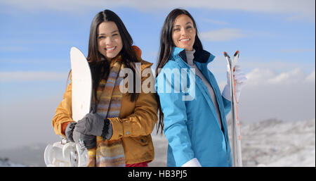 Deux magnifiques jeunes femmes posant avec snowboards Banque D'Images