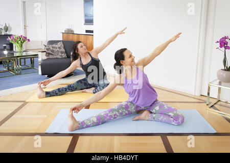 Les femmes faisant du yoga à la maison Banque D'Images