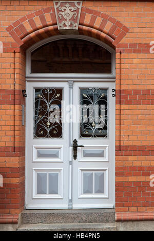 Gray double porte avec windows dans une maison de brique rouge Banque D'Images