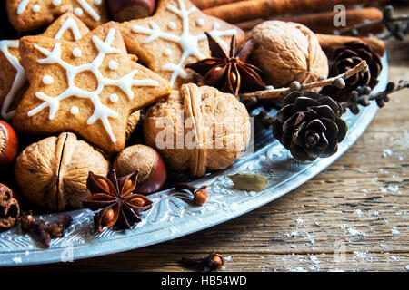 Décoration de Noël avec des biscuits au gingembre stars, cônes, noix et chocolat sur fond de bois rustique, Close up Banque D'Images