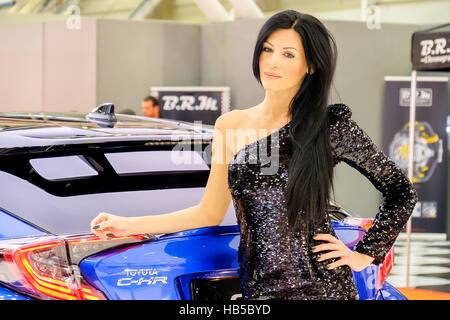 Bologne, Italie, 03 décembre 2016 - un élégant black haired model posing incliné sur une Toyota C-HR voiture pendant le salon de l'automobile 2016 à Bologne Banque D'Images