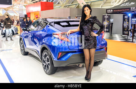 Bologne, Italie, 03 décembre 2016 - un élégant black haired model posing incliné sur une Toyota C-HR voiture pendant le salon de l'automobile 2016 à Bologne Banque D'Images