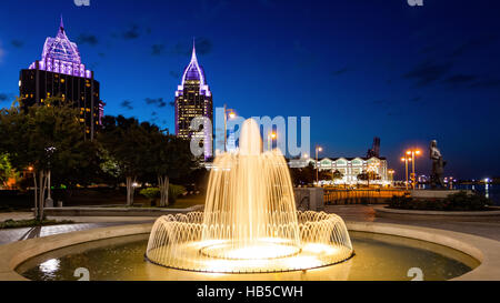 Le centre-ville de Mobile, en Alabama skyline et fontaine à eau à la nuit tombée dans Cooper Riverside Park Banque D'Images