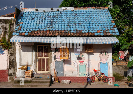 Street art sur le mur d'une maison dans un quartier pauvre de Yogyakarta. L'île de Java en Indonésie. Banque D'Images