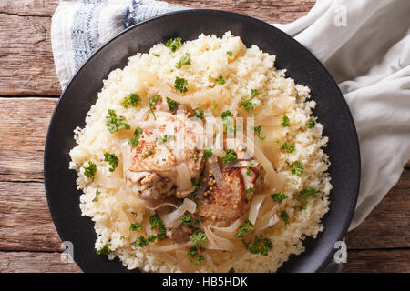 Poulet Yassa avec compote d'oignons marinés et de couscous close up sur une plaque horizontale vue du dessus. Banque D'Images
