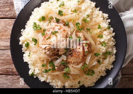 Des plats traditionnels sénégalais : Poulet Yassa avec du couscous et des oignons sur la table horizontale vue du dessus. Banque D'Images