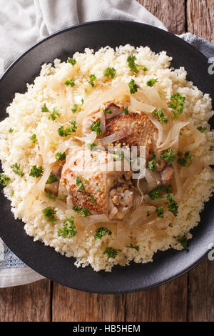 Des plats traditionnels sénégalais : Poulet Yassa avec du couscous et des oignons sur la table. vertical Vue de dessus Banque D'Images
