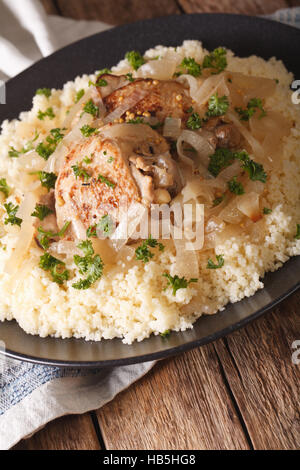 Des plats traditionnels sénégalais : Poulet Yassa avec du couscous et des oignons sur la table verticale. Banque D'Images