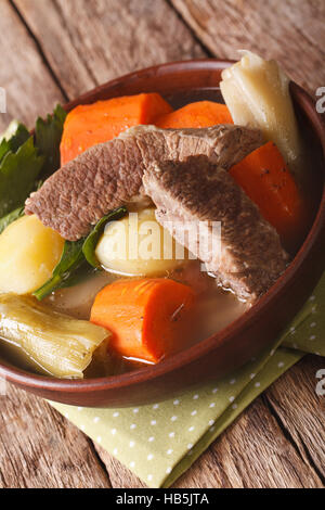 La cuisine française Pot-au-feu près de la soupe dans un bol sur la table verticale. Banque D'Images