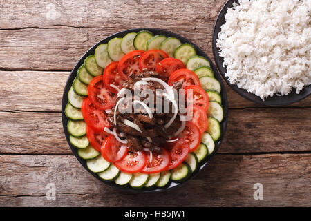 La nourriture cambodgienne : boeuf Lok Lak avec légumes frais et un plat de riz sur la table. Vue du dessus horizontale Banque D'Images