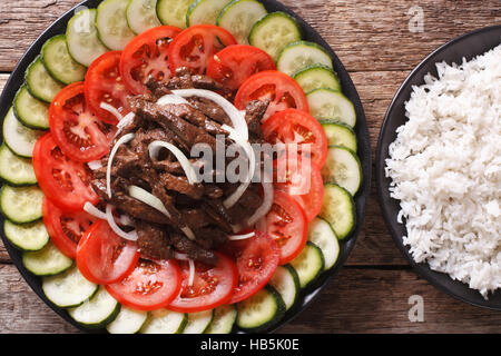 Rôti de bœuf mariné Lok Lak avec légumes frais et un plat de riz sur la table horizontale vue du dessus. Banque D'Images