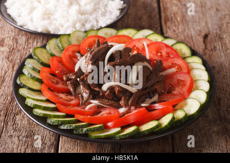 Rôti de bœuf mariné Lok Lak avec légumes frais et un plat de riz sur la table horizontale. Banque D'Images