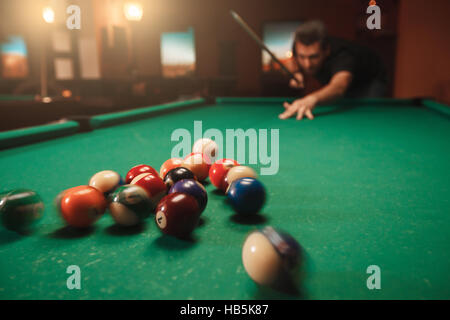 L'homme frappe une pyramide en billard. Banque D'Images