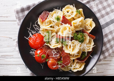 Tortellini fraîchement préparé avec le prosciutto et parmesan gros plan sur une assiette. Vue du dessus horizontale Banque D'Images