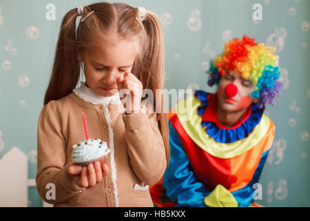Girl holding un gâteau avec une bougie dans ses mains. Banque D'Images
