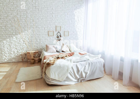 Chambre minimaliste avec grand lit et mur de brique Banque D'Images