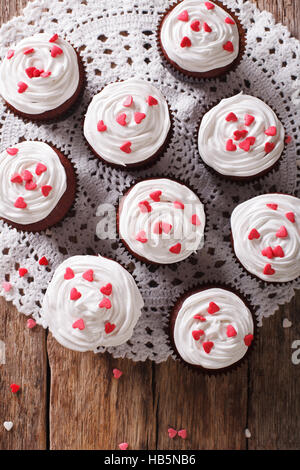 Red Velvet cupcakes savoureux sur une serviette lacy close-up sur la table. vertical Vue de dessus Banque D'Images