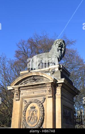 L'un des lions en sculpture sur un pilier en face d'un portique Banque D'Images