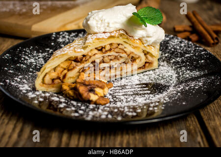 Apple strudel traditionnel ou en secteurs aux noix et à la crème fouettée Banque D'Images