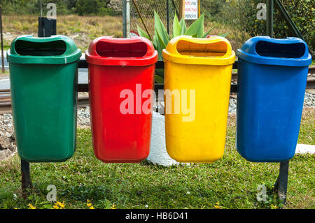 Quatre bacs / conteneurs - vert, rouge, jaune et bleu - dans un parc public au Brésil. Banque D'Images