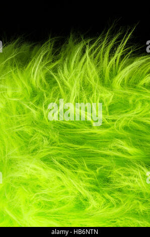 Tissu vert jaune sur fond noir à la verticale. Textile de polyester très doux faits de fibres synthétiques avec les cheveux longs. Macro Banque D'Images