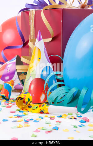 D'anniversaire avec un cadeau ou présent fort, chapeaux de fête, de cornes ou de sifflements, des ballons, des confettis et des serpentins Banque D'Images