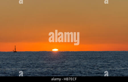 Coucher du soleil sur une calme soirée hivers à l'entrée de Milford Haven avec une bouée cardinale ouest Banque D'Images