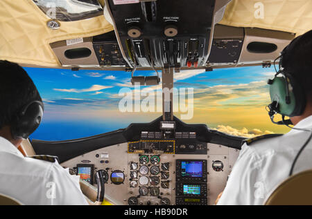 Les pilotes dans le plan de pilotage et le coucher du soleil Banque D'Images