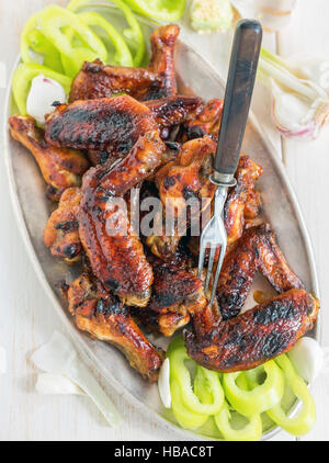Plaque avec des ailes de poulet dans une glaçure. Banque D'Images