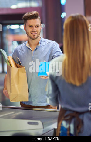 Man holding paper bag plein de shopping Banque D'Images