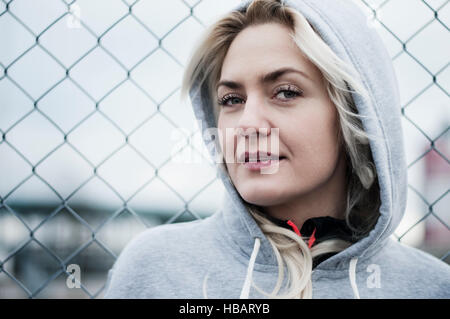 Portrait of mid adult runner par wire fence Banque D'Images