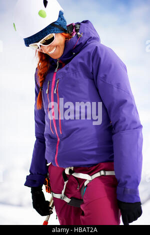 Femme portant des harnais de sécurité et le casque d'escalade à smiling Banque D'Images