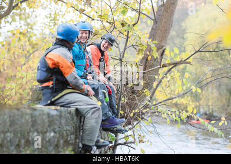 Les kayakistes masculins et féminins assis sur les bords de la rivière mur rire, rivière Dee, Llangollen, Nord du Pays de Galles Banque D'Images