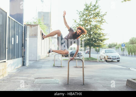 Jeune homme hipster des coups de talons sur le trottoir Banque D'Images