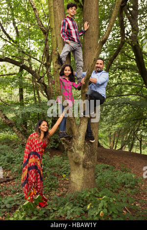 Portrait de famille en forêt, père et deux enfants arbre d'escalade Banque D'Images