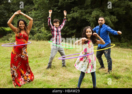 Portrait de famille, standing in field, à l'aide de cerceaux Banque D'Images