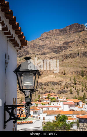 Lampe sur un mur du bâtiment avec les toits des maisons d'une petite ville de Fataga en arrière-plan, Gran Canaria, Îles Canaries, Espagne Banque D'Images