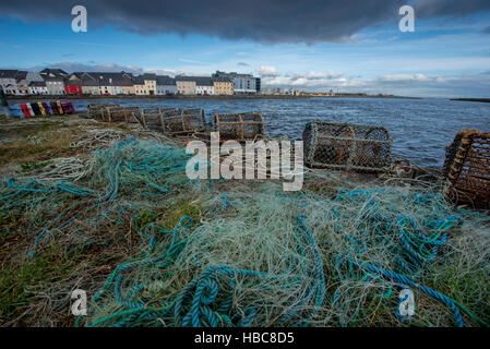 Les filets de pêche au homard et de cages sur Claddagh à Galway. Maisons colorées en arrière-plan. Banque D'Images