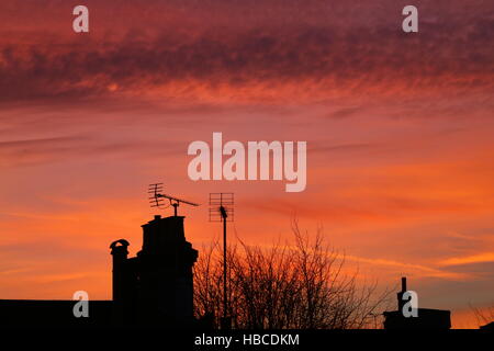 Westcliff on Sea, Essex, Royaume-Uni. 5 déc, 2016. Météo britannique. Ciel rouge du coucher de soleil au-dessus de la cheminée et des pots de toits. Credit : Penelope Barritt/Alamy Live News Banque D'Images