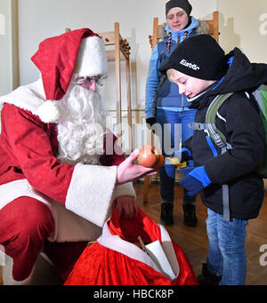 Erfurt, Allemagne. Le 06 Dec 2016. Petit Père Noël distribue des cadeaux aux enfants lors de l'ouverture du restaurant du coeur à Erfurt, Allemagne, 06 décembre 2016. L'hiver dernier autour de 160 personnes recieved repas chaque jour, pour un total d'environ 6 000 repas. Le restaurant accueille les personnes dans le besoin et leur fournit des aliments chauds, du café et des gâteaux. Il reste ouvert en semaine jusqu'à la fin de janvier 2017. Photo : Martin Schutt/dpa-Zentralbild/dpa/Alamy Live News Banque D'Images